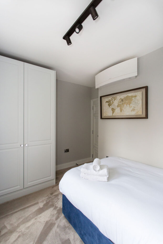 renovated bedroom with small wardrobe and double bed