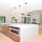 white kitchen with large island and lounge space